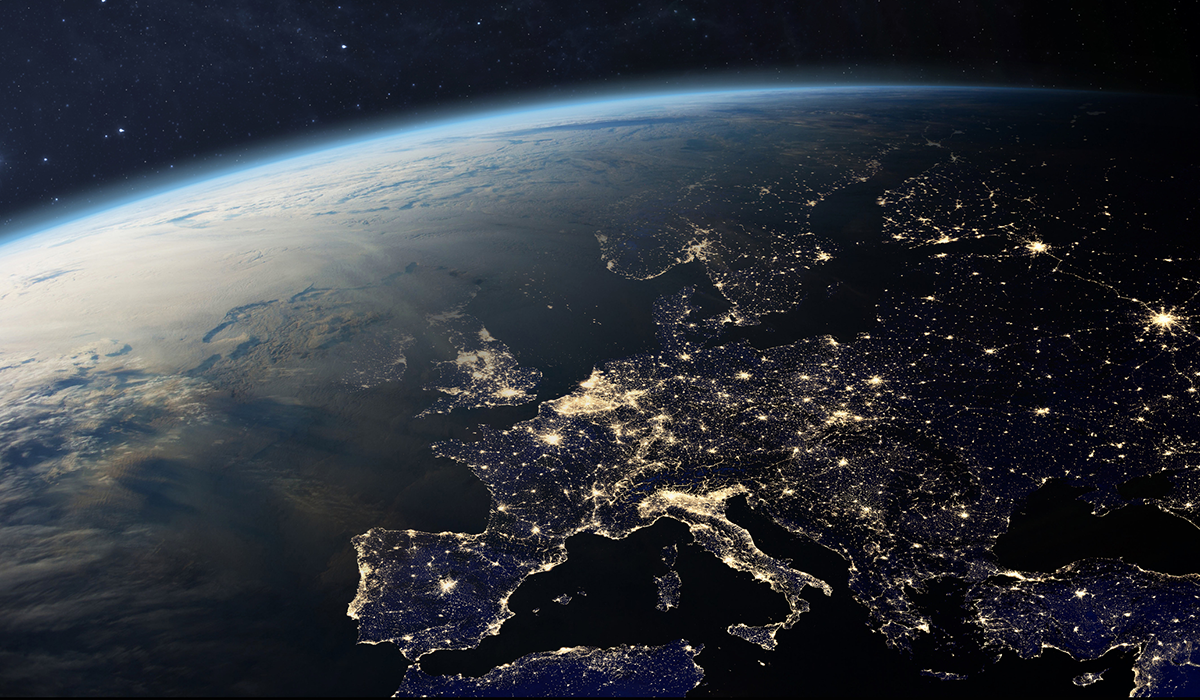 Satellite view of Europe at night with the cities showing up as bright spots of light.