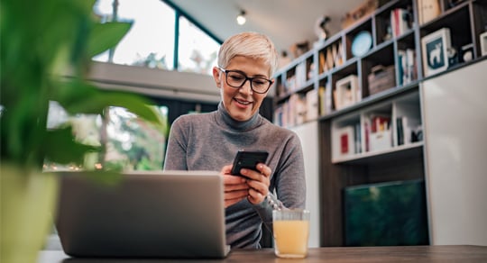 Person checking their phone in a home office.